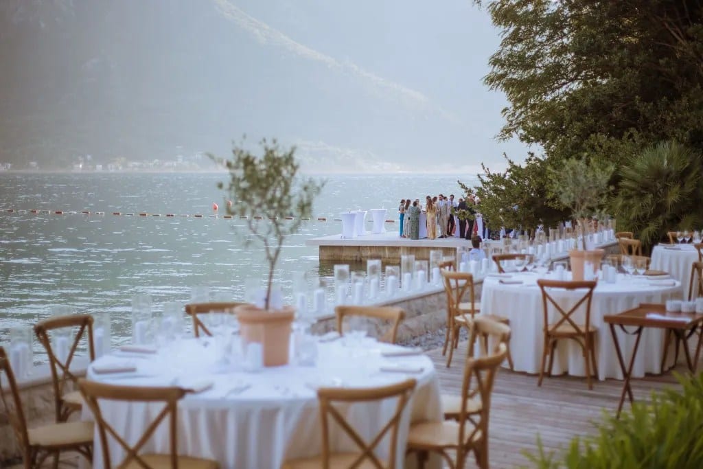 Waterfront wedding tables with ceremony and mountain amphitheatre