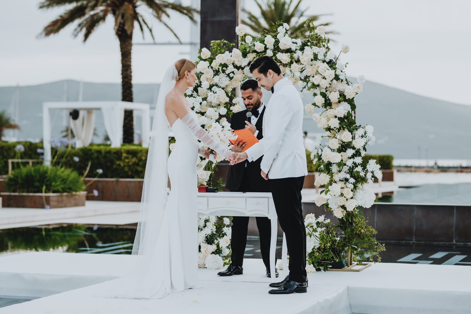 Modern Montenegro ceremony with palm and white floral arch